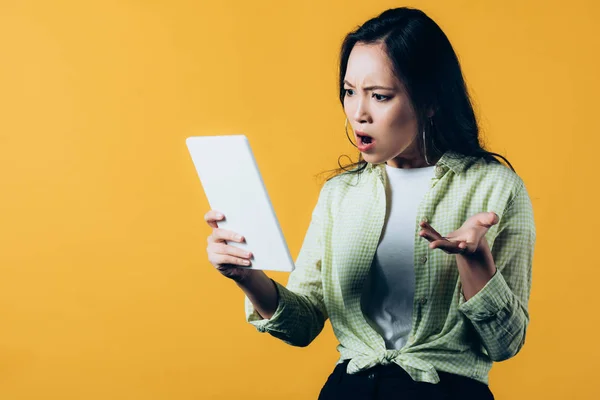 Θυμωμένη Ασιατική Γυναίκα Χρησιμοποιώντας Ψηφιακό Δισκίο Απομονώνεται Κίτρινο — Φωτογραφία Αρχείου