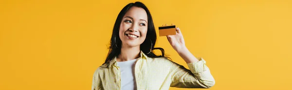 Sorrindo Asiático Mulher Segurando Cartão Crédito Isolado Amarelo — Fotografia de Stock