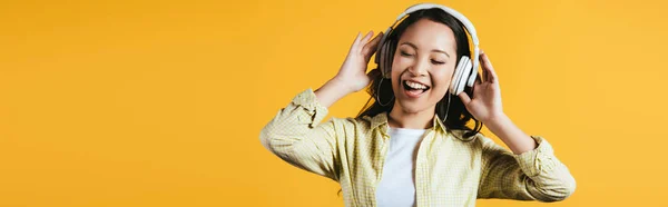 Feliz Chica Asiática Cantando Escuchando Música Con Auriculares Aislado Amarillo — Foto de Stock