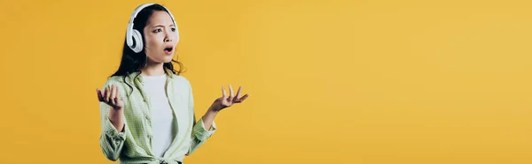 Приваблива Розчарована Азіатська Жінка Слухає Музику Навушниками Ізольована Жовтому — стокове фото