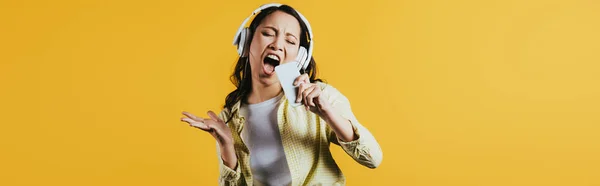 Emotional Asian Girl Singing Listening Music Headphones Smartphone Isolated Yellow — Stock Photo, Image