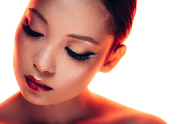 attractive asian woman with makeup in red light, isolated on white