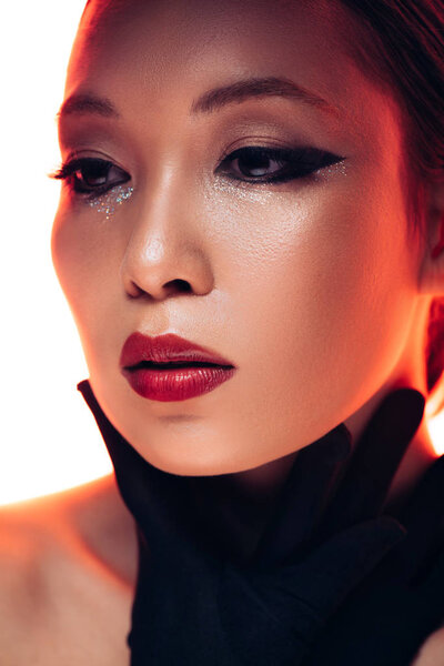 asian model in black gloves in red light, isolated on white