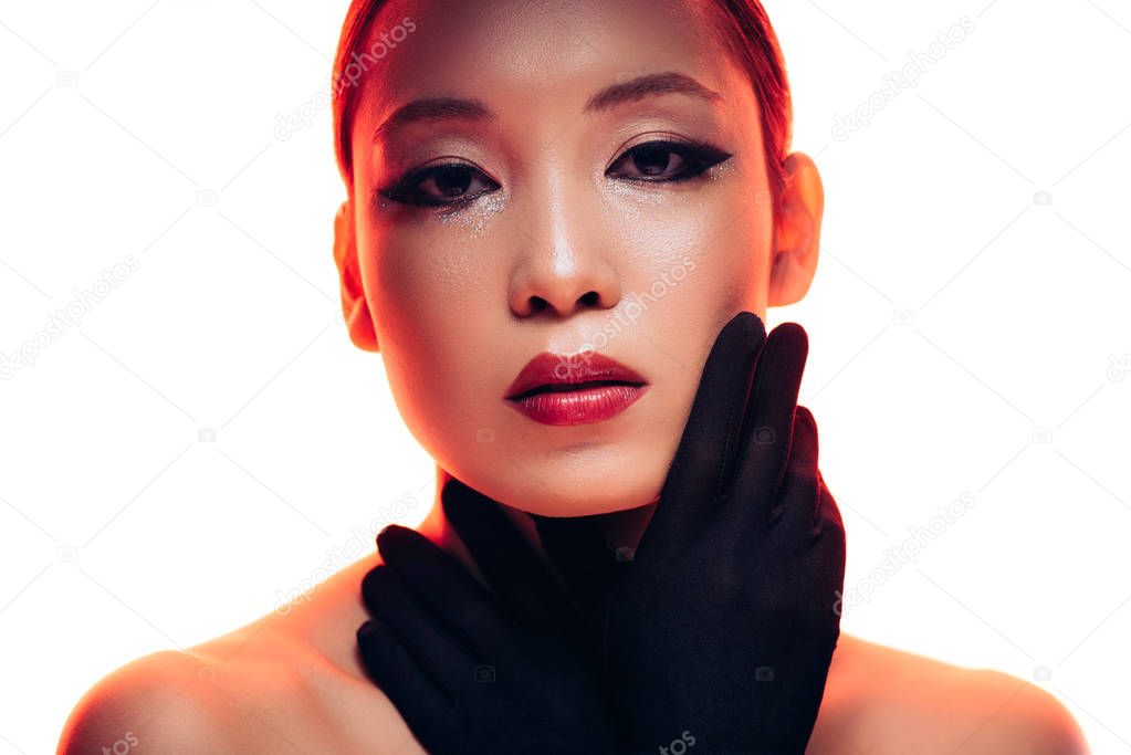 attractive asian girl in black gloves with makeup in red light, isolated on white