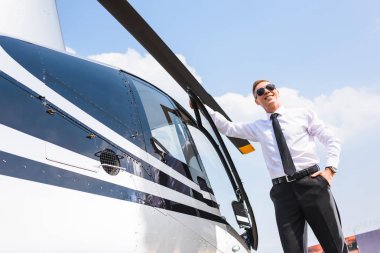 resmi aşınma ve helikopter yakın gülümseyen güneş gözlüğü yakışıklı pilot