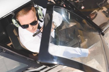 helikopter kabininde oturan güneş gözlüğü ve kulaklık pilot üst görünümü