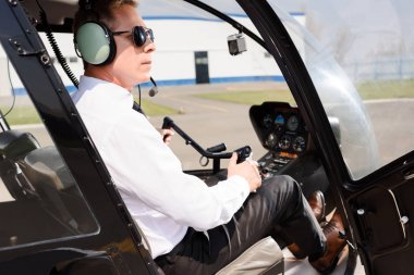 Helikopter kabin ve tutarak tekerlek oturan güneş gözlüğü ve kulaklık pilot