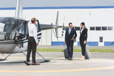 pilot ve helikopter yakınındaki bavullar ile resmi aşınma iş ortakları