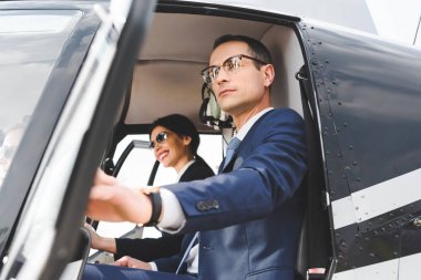 iş kadını ve işadamı helikopter kabininde oturuyor