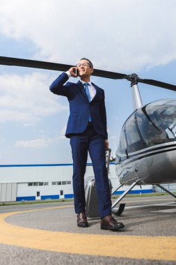 helikopter yakın Smartphone konuşurken bavul ile resmi aşınma işadamı