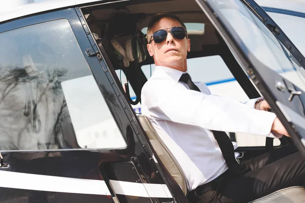 helikopter kabininde oturan güneş gözlüğü ve resmi aşınma emin pilot