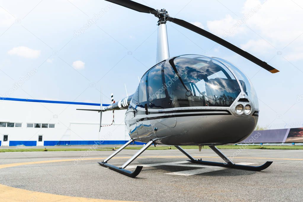 helicopter with propeller on concrete Helipad during daytime