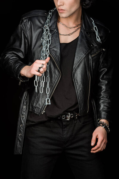 обрезанный вид человека, держащего металлические цепи, находясь в изоляции на черном
 