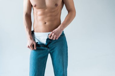 beyaz üzerinde mavi kot çıkararak gömleksiz adam kırpılmış görünümü 