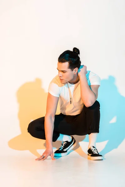 Hombre Guapo Camiseta Blanca Sentado Blanco Con Iluminación — Foto de Stock