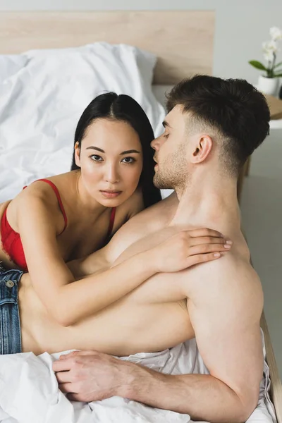 Sexy Asian Woman Looking Camera While Embracing Shirtless Handsome Boyfriend — Stock Photo, Image
