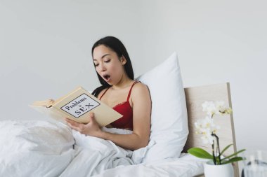yatakta yatarken seks kitabında sorunları okuma şok asyalı kadın