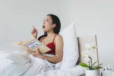 seks kitabında sorunları okurken fikir işareti gösteren asyalı kadın şaşırttı 