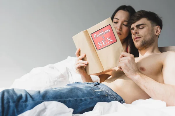 Jong Interraciaal Paar Lezen Problemen Geslacht Boek Terwijl Liggend Bed — Stockfoto