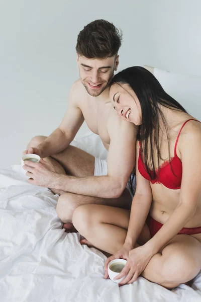 Cheerful Loving Interracial Couple Sitting Bed Crossed Legs Holding Coffee — Stock Photo, Image