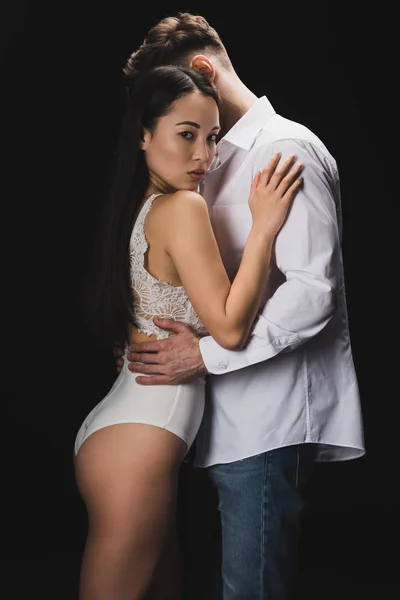 白いランジェリーでセクシーなアジアの女性はボーイフレンドを抱きしめ 黒で隔離されたカメラを見て — ストック写真
