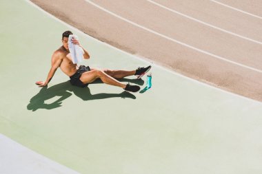 karışık yarış sporcusu stadyumda oturan ve havlu ile yüz silme
