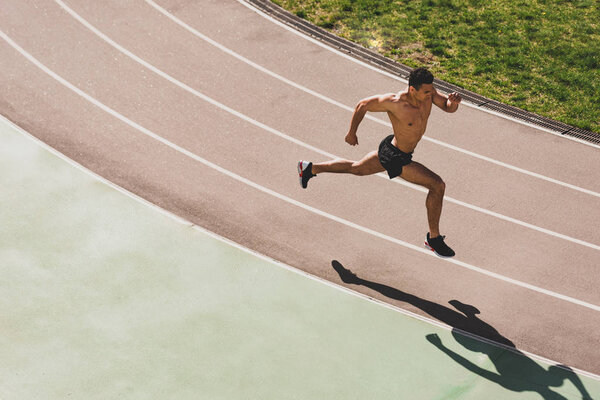 overhead view of mixed race sportsman running at stadium