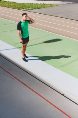 stadyumda yorgun karışık yarış sporcusu ayakta tam uzunlukta görünümü