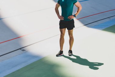 stadyumda kalça elleri ile sporcunun ayakta görünümü kırpılmış