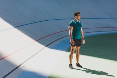 Koşu pistine yakın stadyumda ışık yerinde karışık yarış sporcusu ayakta
