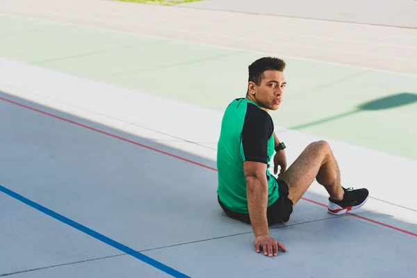 Schöner Mixed Race Sportler Sitzt Auf Der Laufbahn Und Blickt — Stockfoto