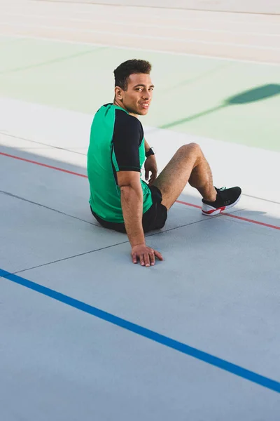 Apuesto Deportista Carreras Mixtas Sentado Pista Atletismo Sonriendo Mirando Cámara — Foto de Stock