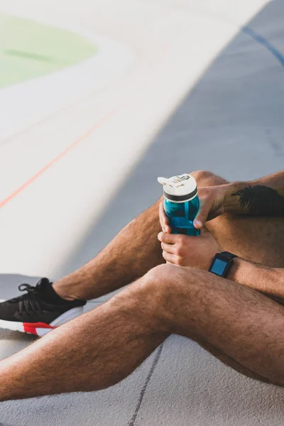 Cropped View Sportsman Sitting Stadium Holding Blue Bottle Water — Stock Photo, Image