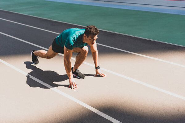 спортсмен смешанной гонки на стартовой позиции на стадионе
 