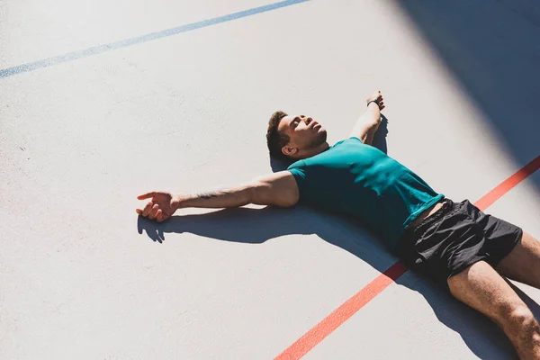 Mixed Race Sportsman Laying Running Track Spread Arms Sunlight — Stock Photo, Image