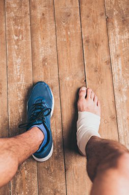 elastik bandaj bir ayak ile bir spor ayakkabı oturan yaralı sporcu kısmi görünümü