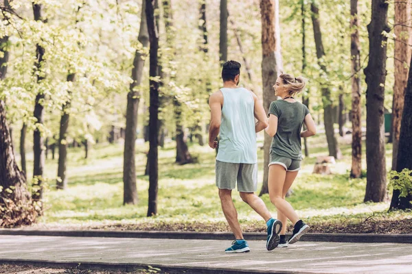 Fiatal Férfi Női Sportruházatban Beszél Kocogás Közben Zöld Parkban — Stock Fotó