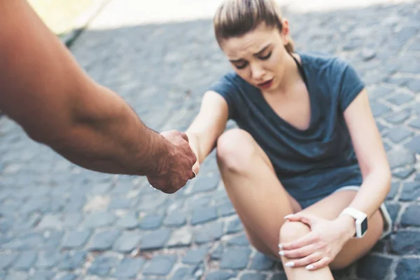 Tiro Recortado Del Hombre Dando Mano Deportista Lesionada Sentada Pavimento —  Fotos de Stock