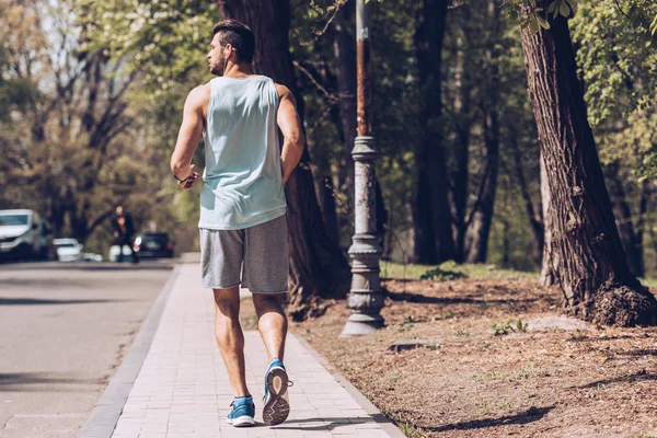 포장도로를 달리는 스포츠맨의 뒷모습 — 스톡 사진