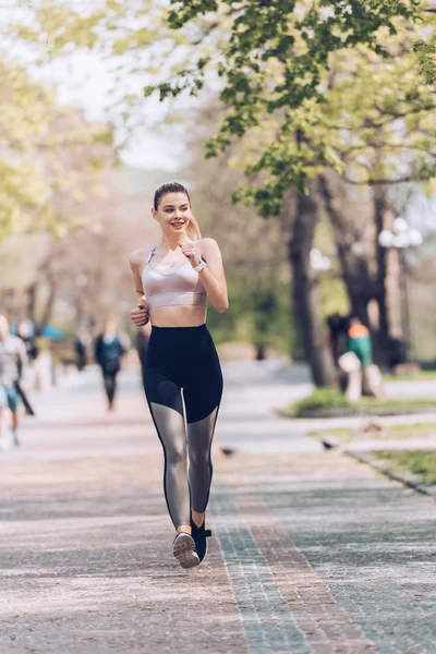 Grazioso Sportivo Sorridente Mentre Jogging Lungo Ampia Passerella Nel Parco — Foto Stock