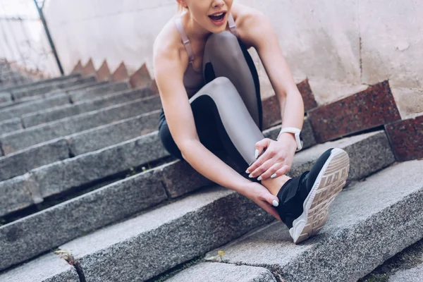 Молодая Спортсменка Сидящая Лестнице Страдающая Боли Прикосновении Поврежденной Ноге — стоковое фото