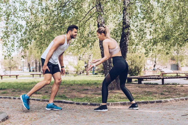 Young Sportswoman Gesturing While Standing Sportsman Suffering Pain Injured Leg — 스톡 사진