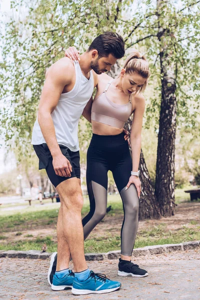 Joven Deportista Con Pierna Lesionada Caminando Mientras Apoyada Por Apuesto — Foto de Stock