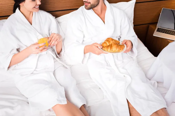 Ostříhané Zobrazení Veselého Muže Který Drží Croissanty Zatímco Leží Ženy — Stock fotografie