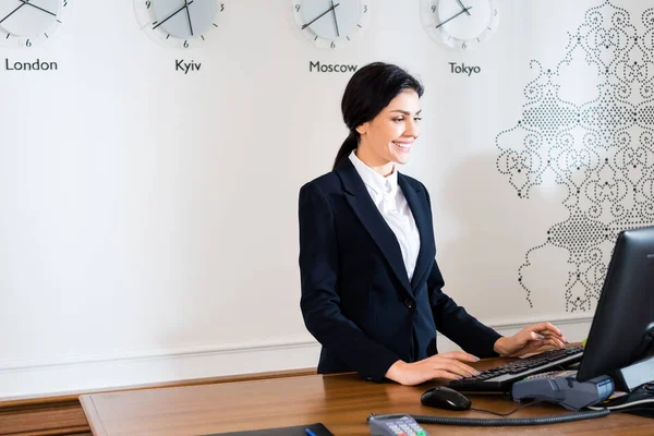 Happy Brunette Receptionist Formal Wear Standing Computer Monitor Hotel — Stock Photo, Image