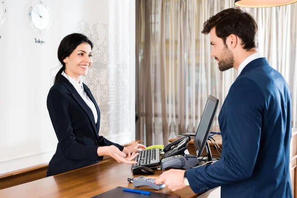 Foco Seletivo Feliz Recepcionista Gesto Perto Homem Bonito Com Cartão — Fotografia de Stock