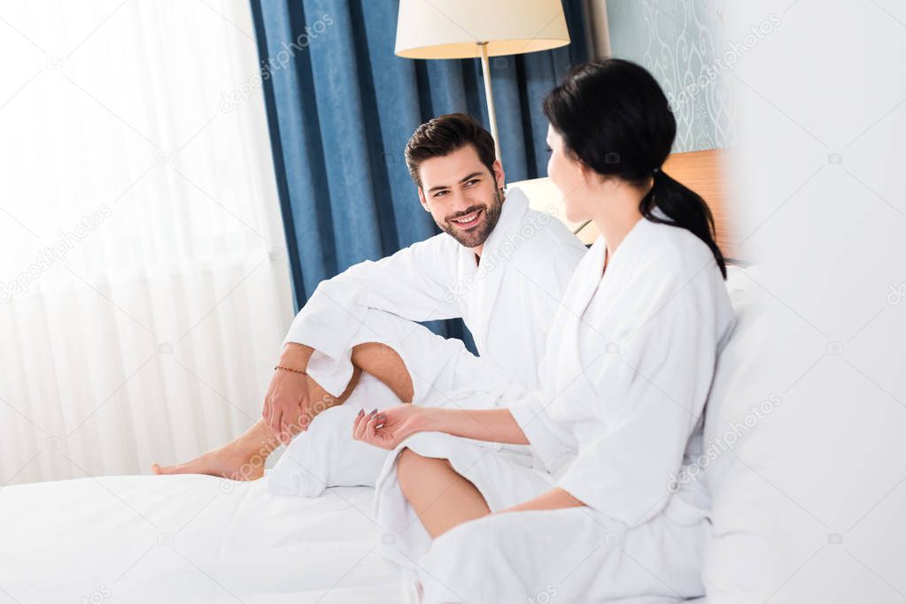 selective focus of cheerful man looking at woman in hotel room 