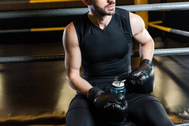 spor salonunda spor şişesi tutan boks eldivenadam kırpılmış görünümü 