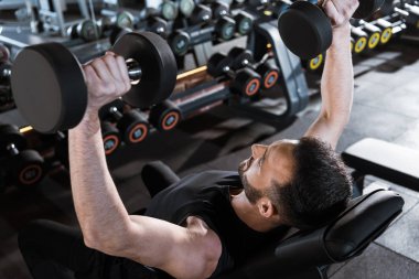 yakışıklı güçlü adam spor salonunda dumbbells ile çalışan havai görünümü 