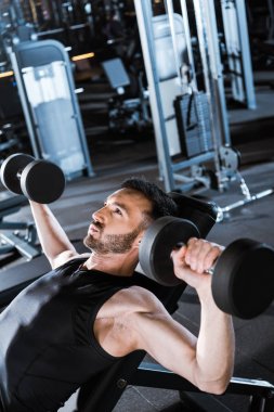 spor salonunda dumbbells ile çalışan güçlü sakallı adam seçici odak 